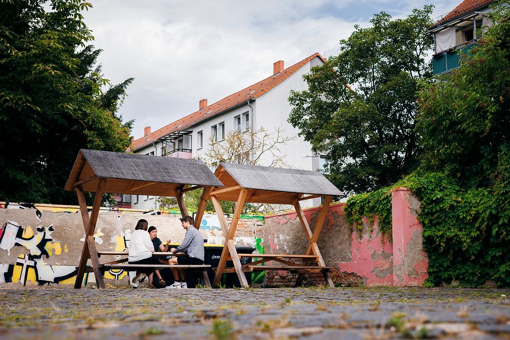 Drei Personen sitzen an einem Tisch und unterhalten sich.